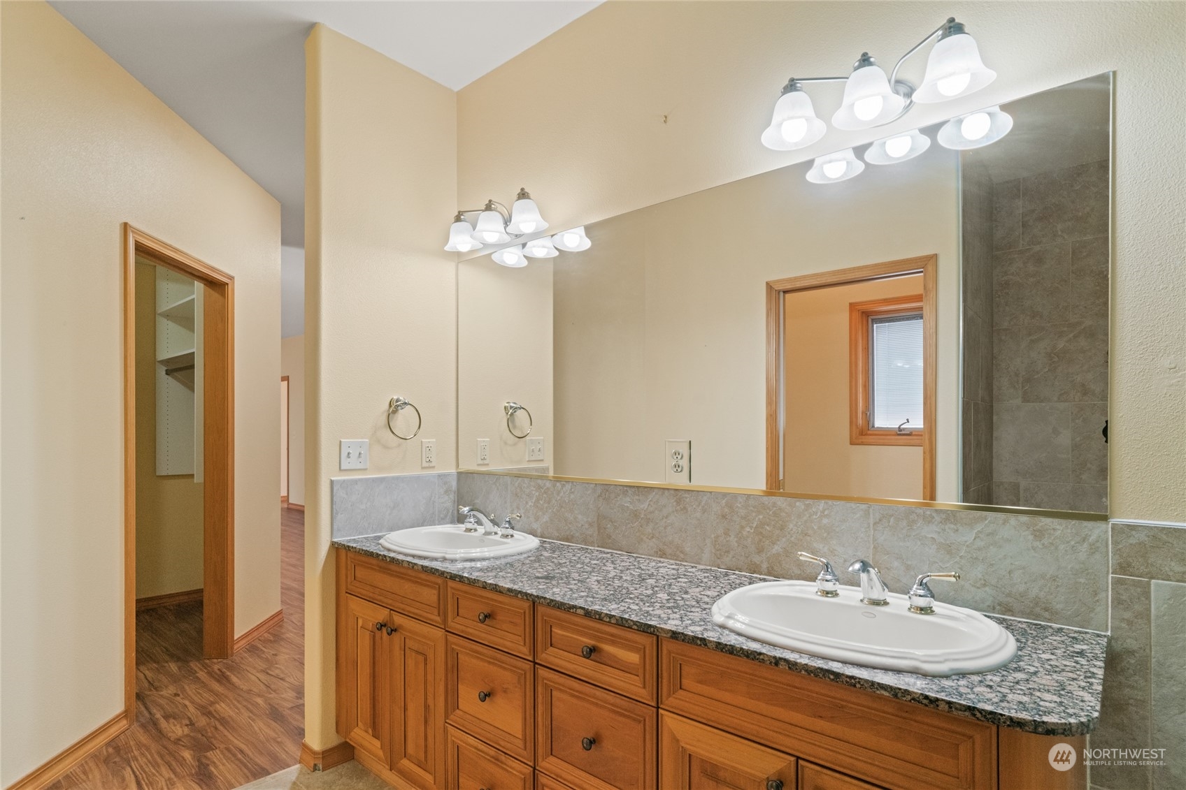 8 Valley View Park Road Omak, WA 98841 - Photo 23 of 40 a bathroom with a granite countertop sink a large mirror and a light fixture