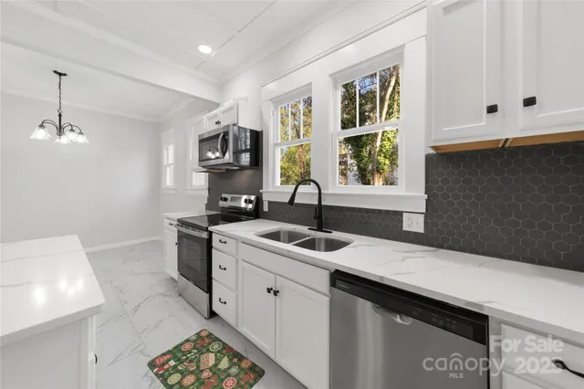 a kitchen with stainless steel appliances granite countertop a sink stove and cabinets