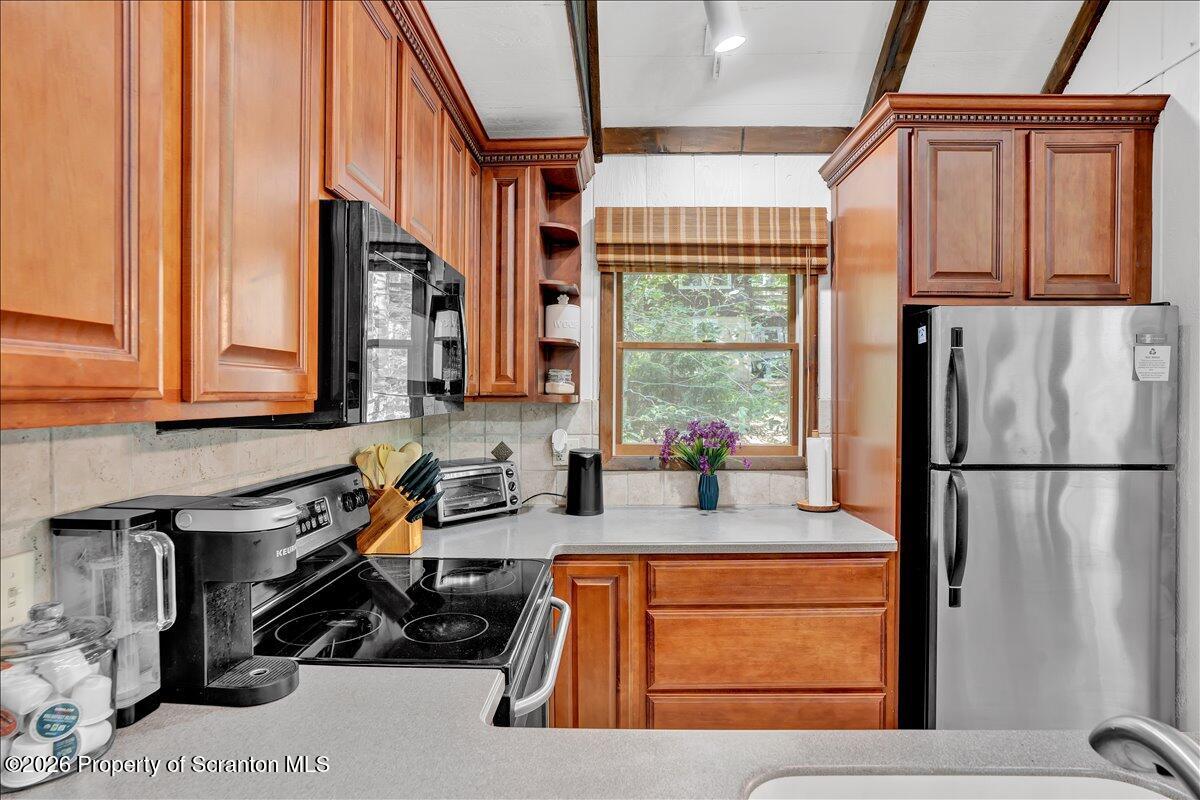 58 Sheffick Road Gouldsboro, PA 18424 - Photo 12 of 44 a kitchen with stainless steel appliances granite countertop a refrigerator a stove and a sink with wooden floor