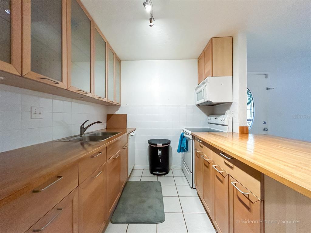 1015 Southwest 9th Street, Unit D2 Gainesville, FL 32601 - Photo 7 of 14 a kitchen with stainless steel appliances granite countertop a sink and cabinets