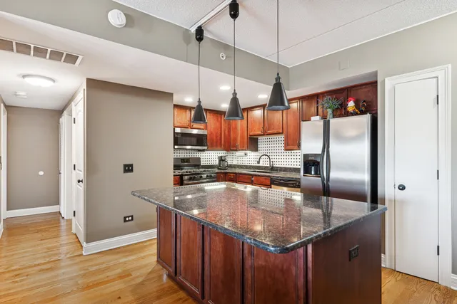 a kitchen with stainless steel appliances granite countertop a sink a refrigerator and window