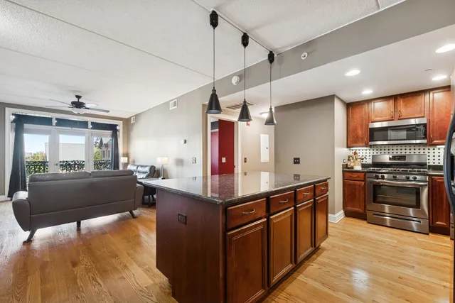 a kitchen with stainless steel appliances kitchen island granite countertop a stove and a refrigerator