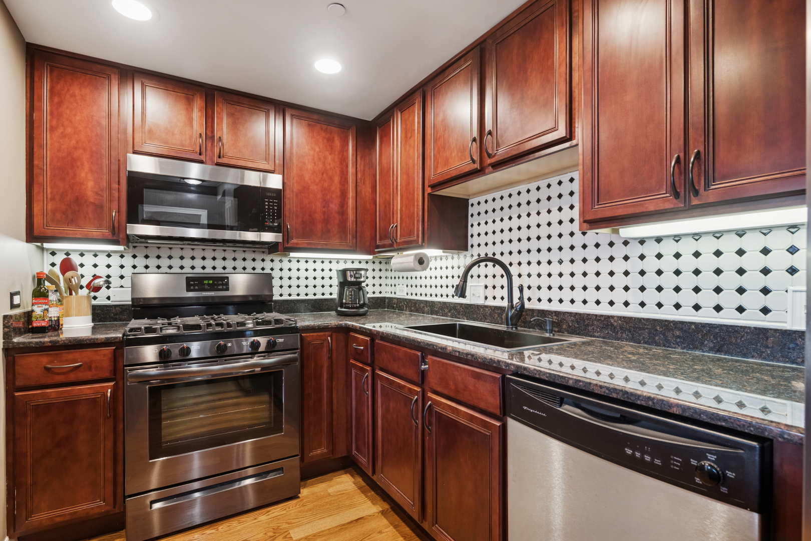 310 South Main Street, Unit 314 Lombard, IL 60148 - Photo 7 of 18 a kitchen with granite countertop cabinets stainless steel appliances and wooden cabinets