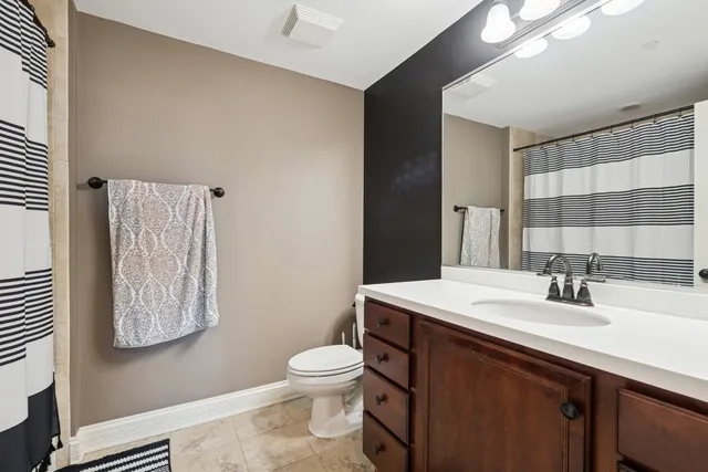 a bathroom with a sink a toilet and mirror