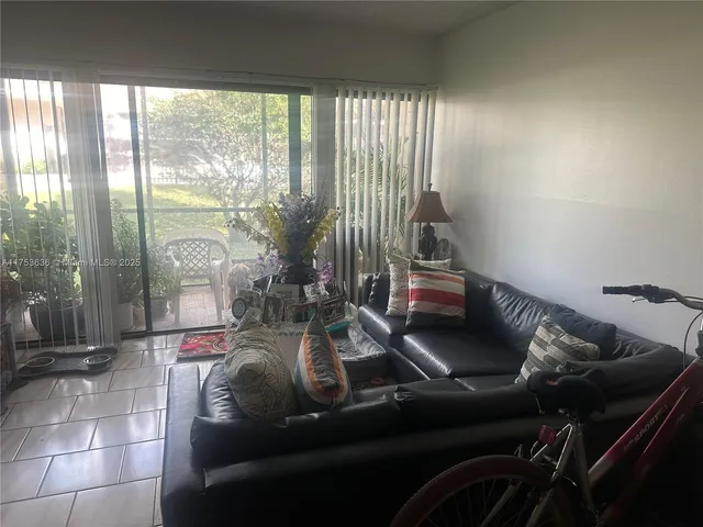 a living room with furniture and a floor to ceiling window