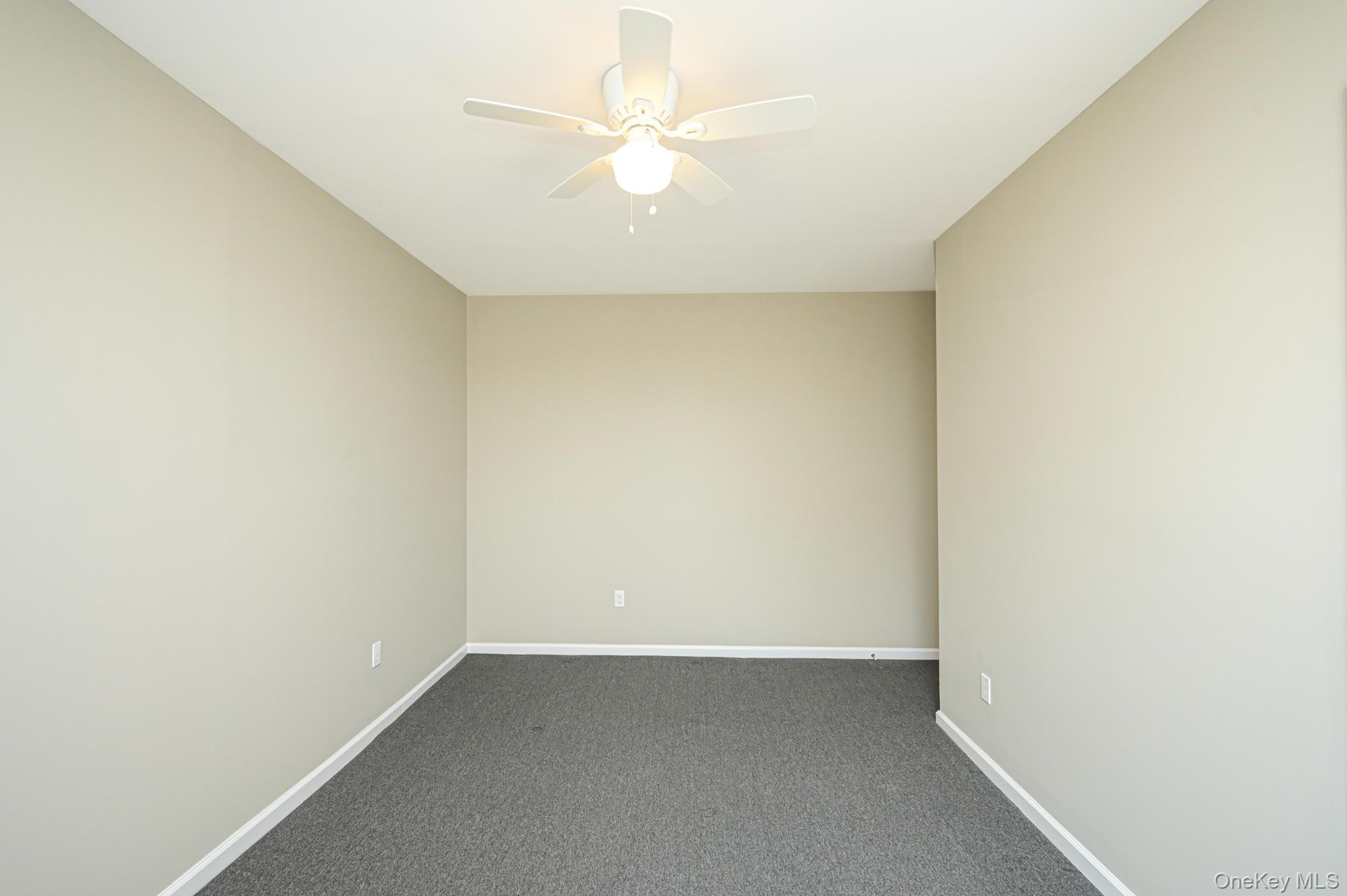 463-465 Main Street, Unit A Islip, NY 11751 - Photo 11 of 15 an empty room with a ceiling fan and a window