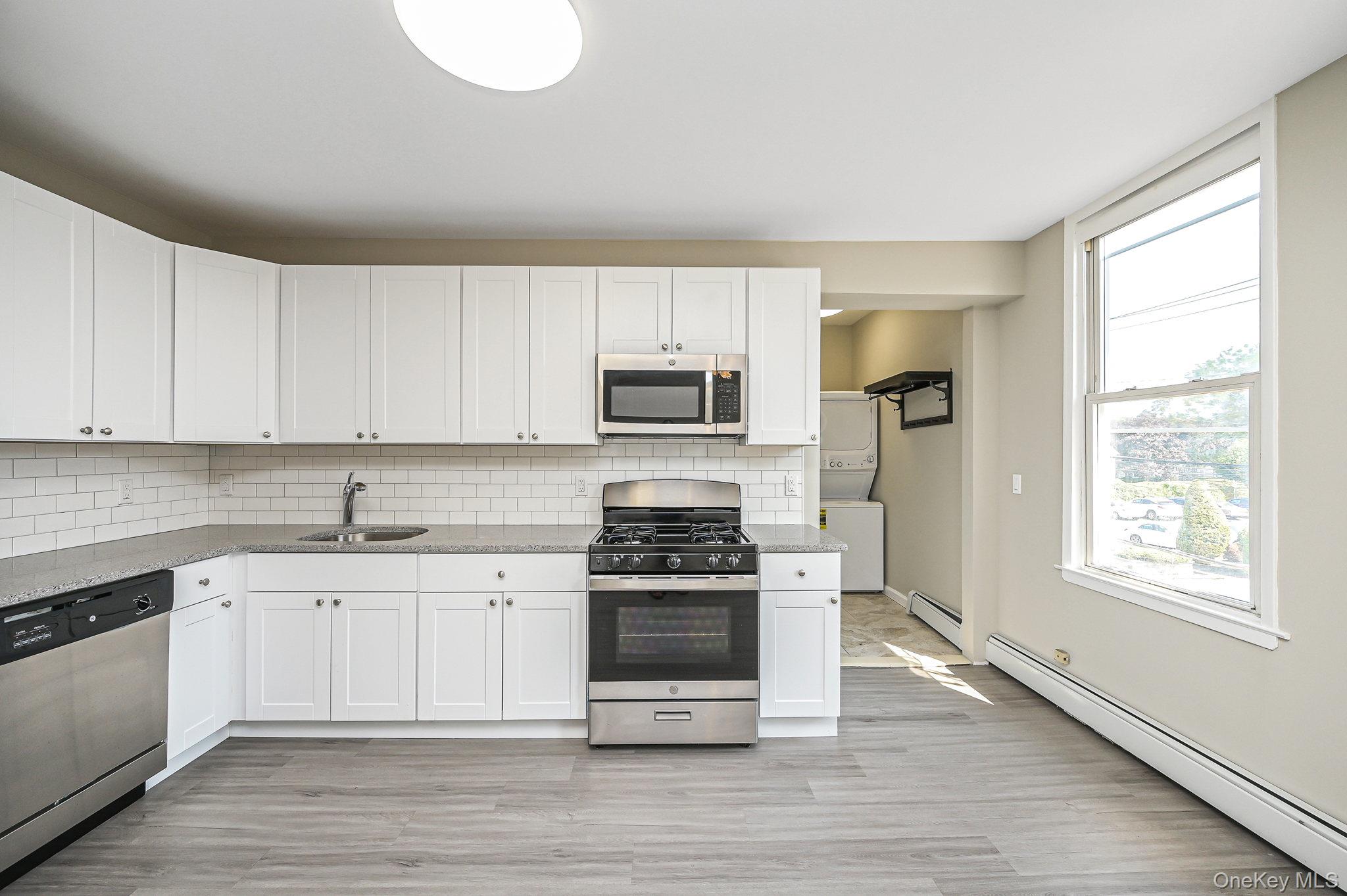 463-465 Main Street, Unit A Islip, NY 11751 - Photo 4 of 15 a kitchen with granite countertop a stove a sink and a microwave