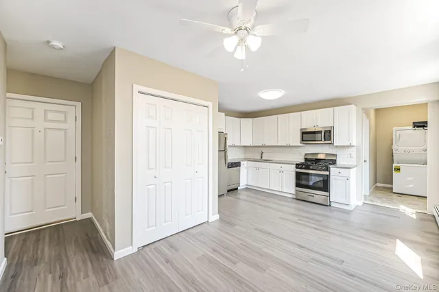 a open kitchen with white cabinets and stainless steel appliances