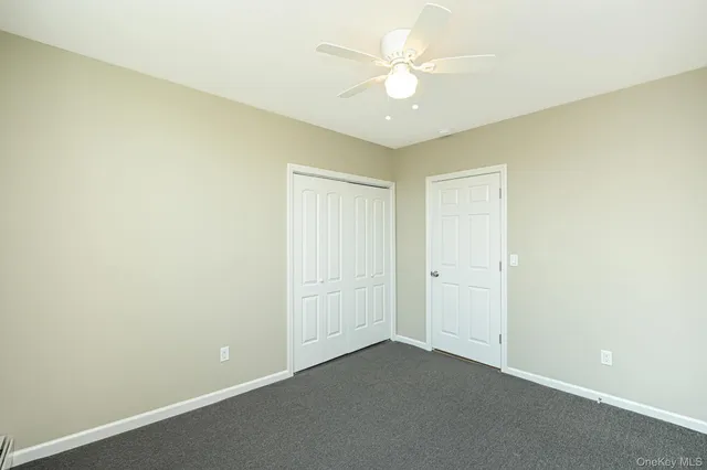 an empty room with a ceiling fan and a window