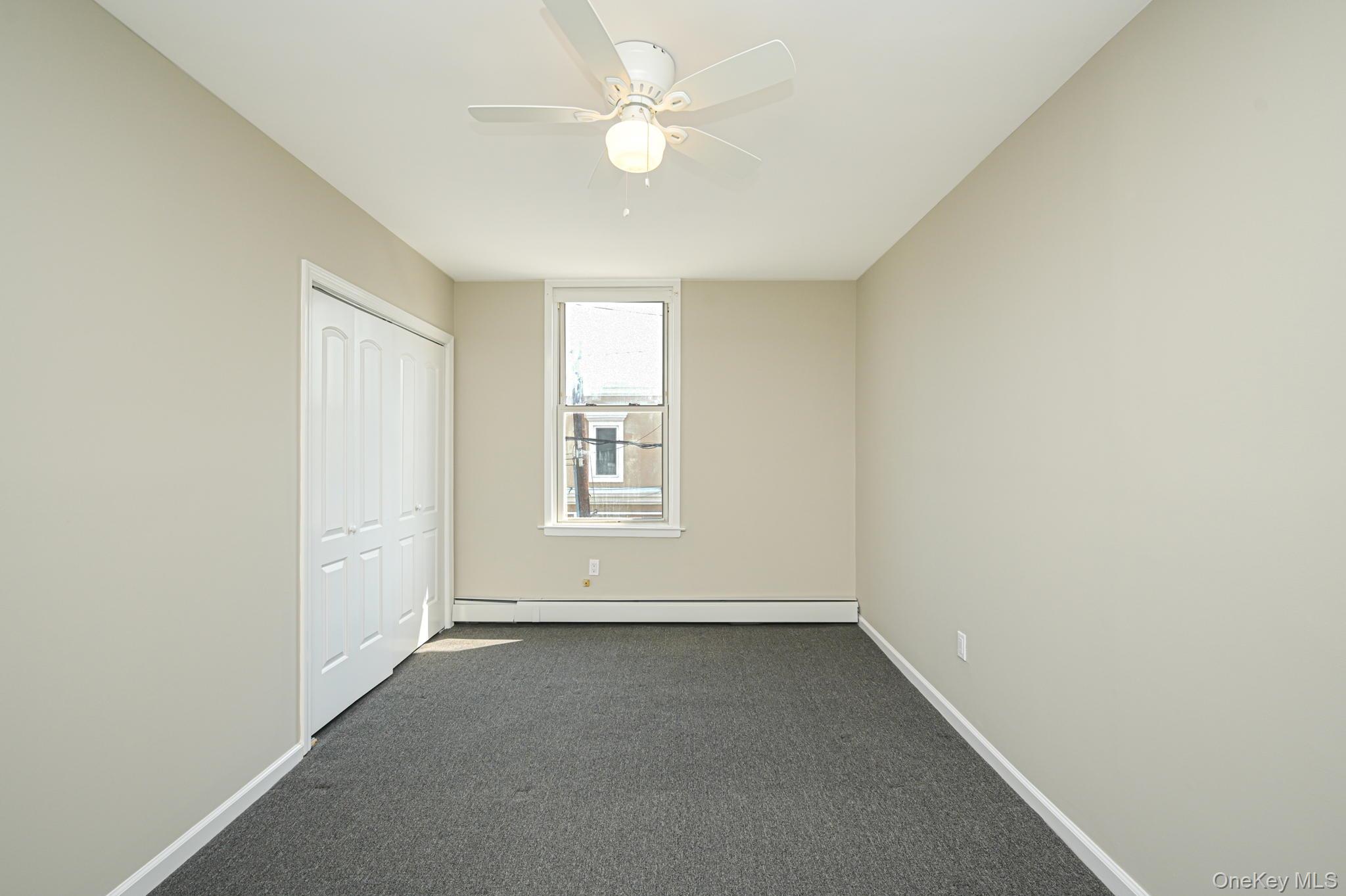 463-465 Main Street, Unit A Islip, NY 11751 - Photo 10 of 15 an empty room with a window and a ceiling fan