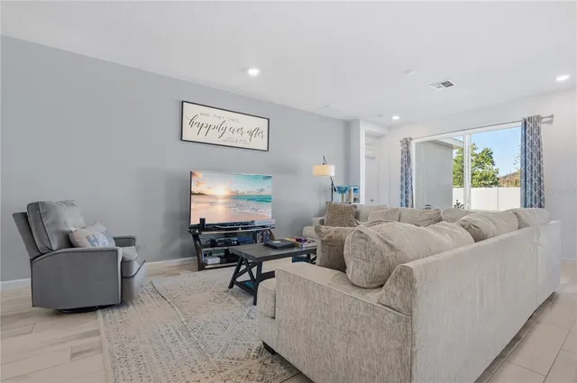 a kitchen with stainless steel appliances granite countertop a refrigerator a sink dishwasher a stove and a dining table with wooden floor