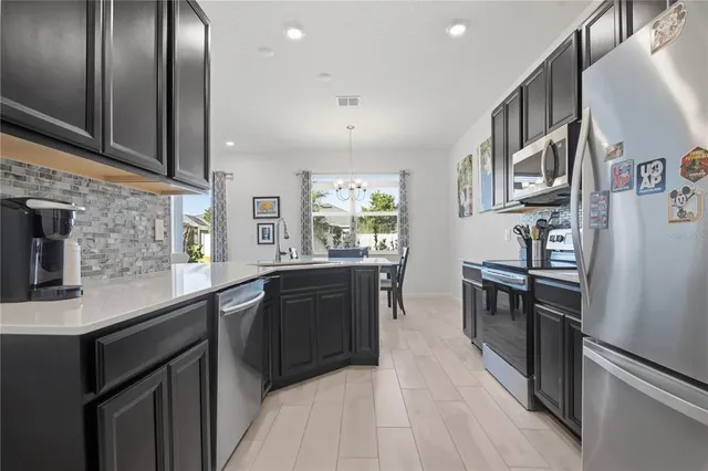 a kitchen with stainless steel appliances a refrigerator sink and stove