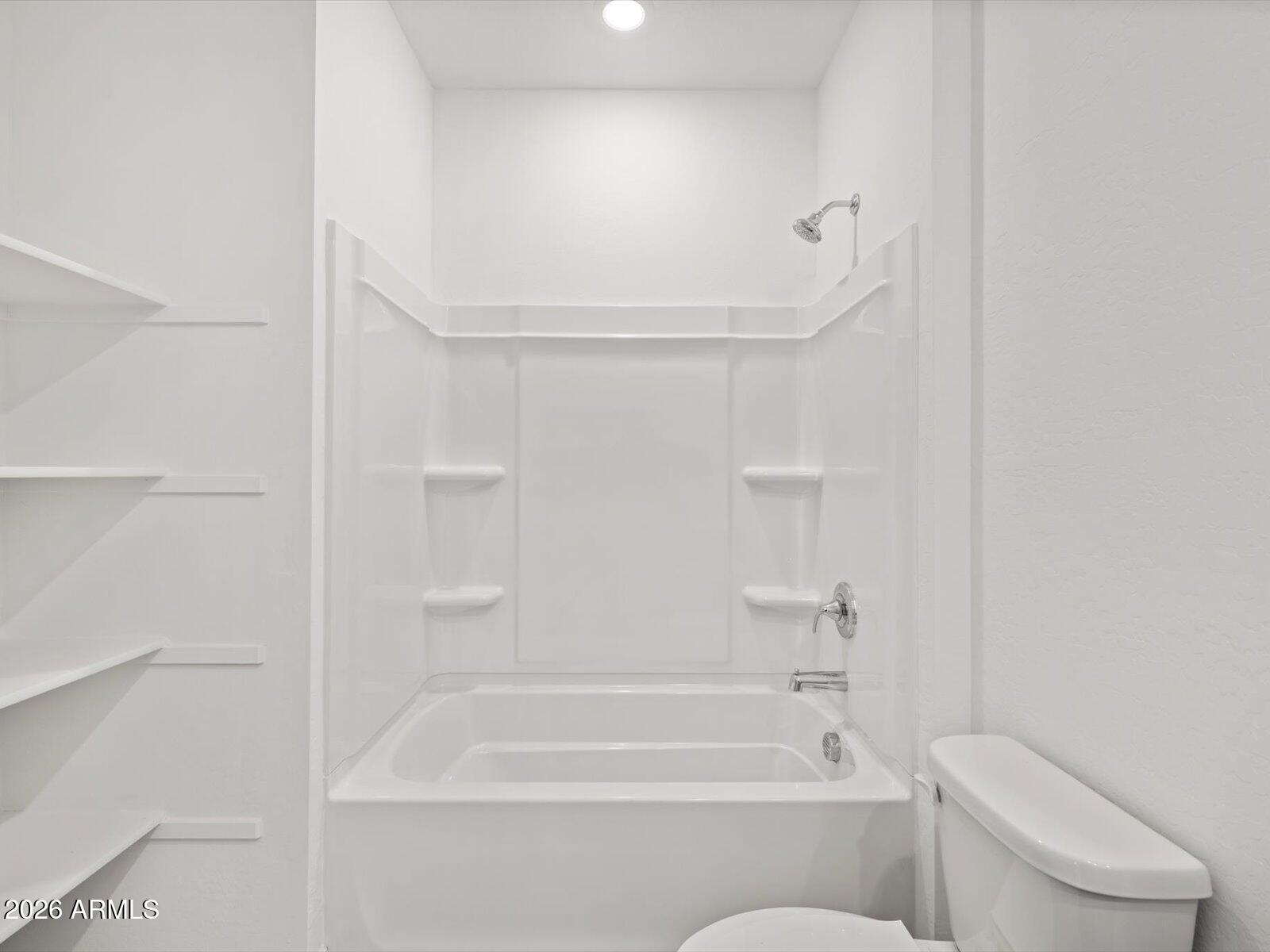 8936 South 244th Lane Buckeye, AZ 85326 - Photo 12 of 45 a bathroom with a toilet and a bath tub