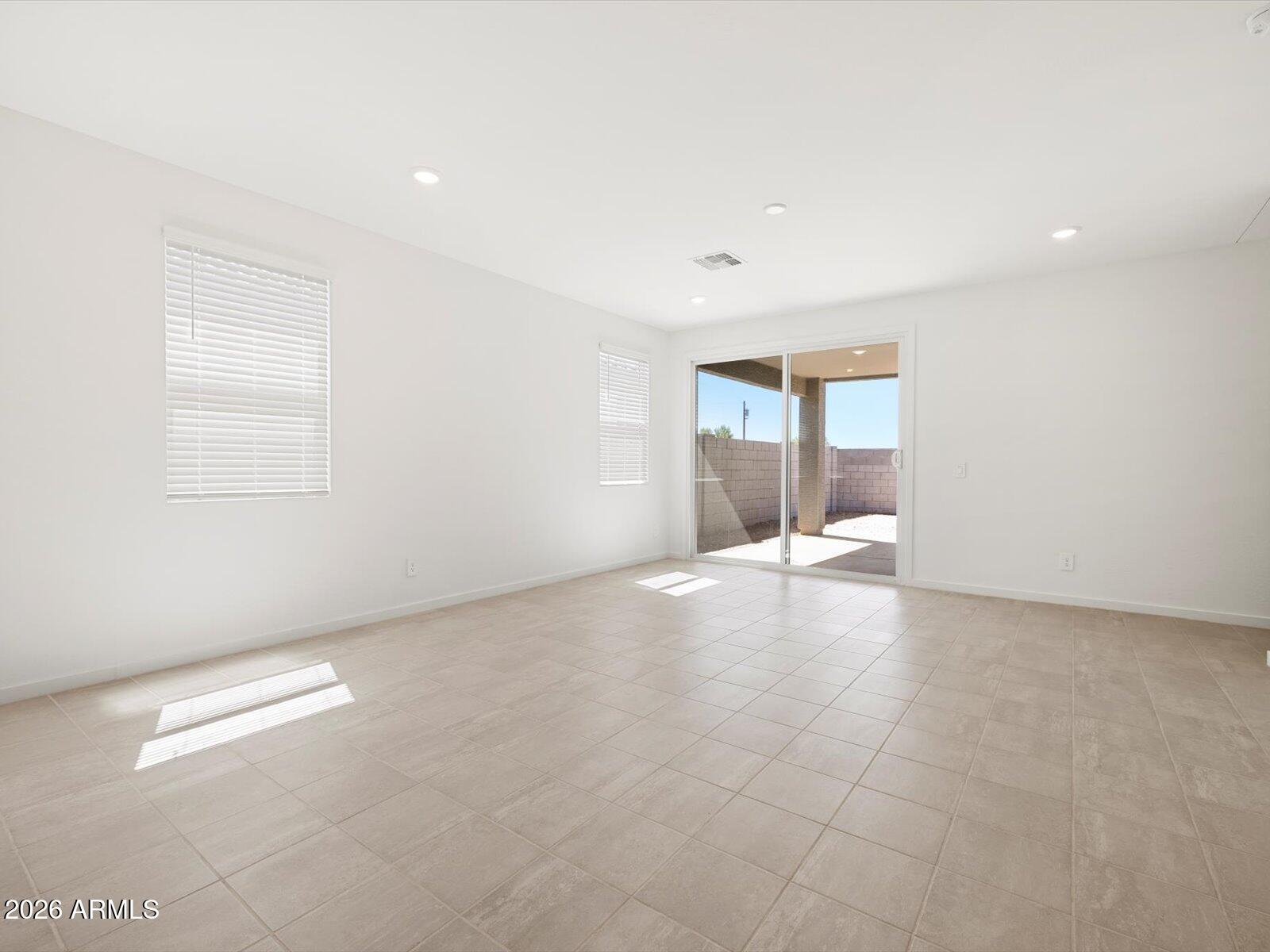 8936 South 244th Lane Buckeye, AZ 85326 - Photo 31 of 45 an empty room with windows and view of kitchen