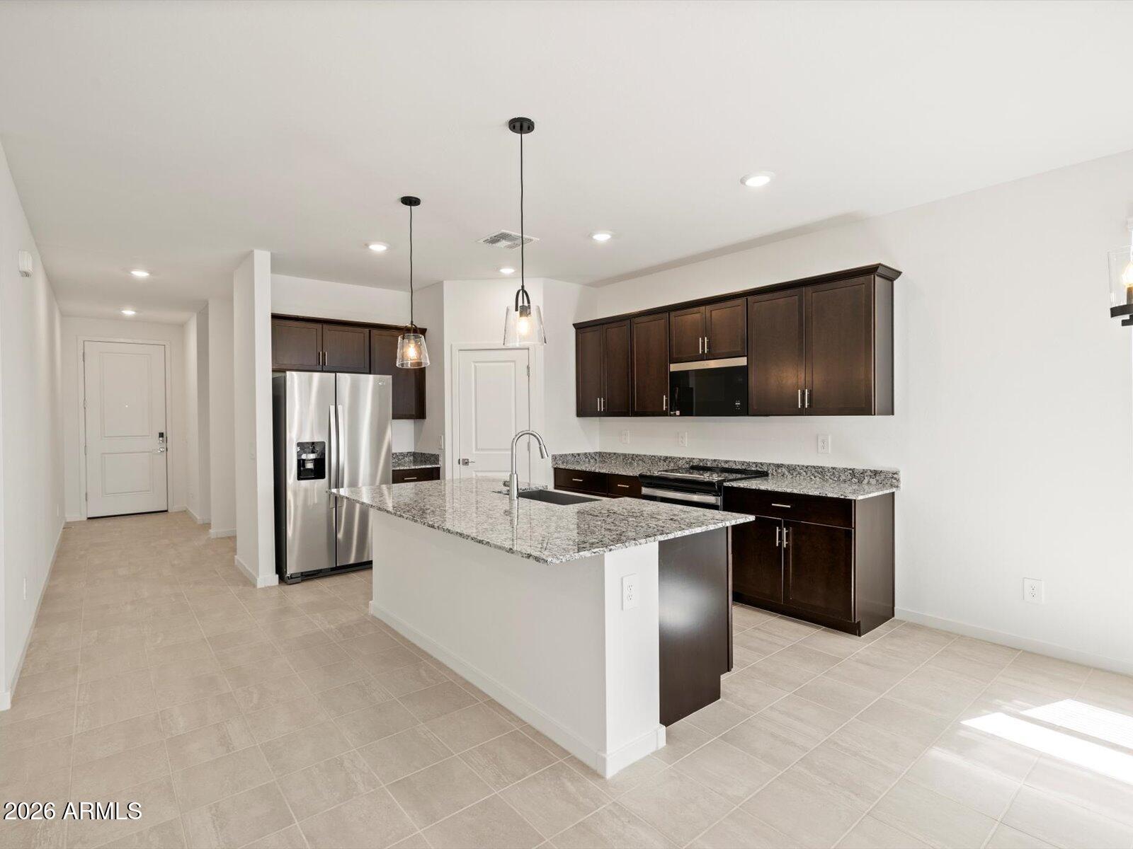 8936 South 244th Lane Buckeye, AZ 85326 - Photo 39 of 45 a kitchen with stainless steel appliances a stove a refrigerator and a microwave