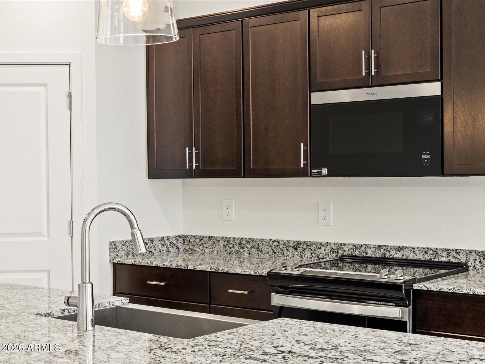 8936 South 244th Lane Buckeye, AZ 85326 - Photo 40 of 45 a close view of a stove top oven and cabinets