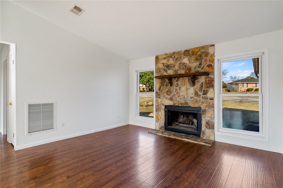 2305 Millgate Road Anderson, SC 29621 - Photo 3 of 18 A welcoming living area boasts beautiful wood flooring and a floor-to-ceiling stone fireplace.