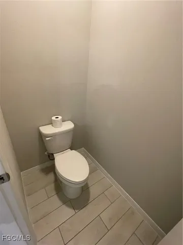 a white toilet sitting next to a white wall
