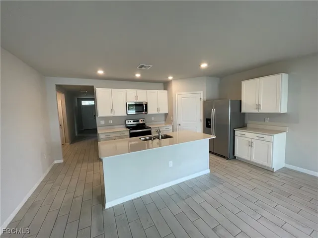 a large kitchen with stainless steel appliances and a refrigerator