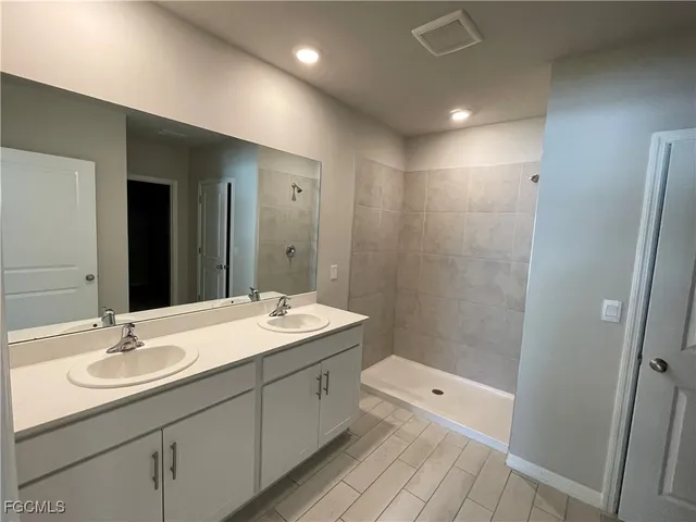 a bathroom with a sink shower and a mirror