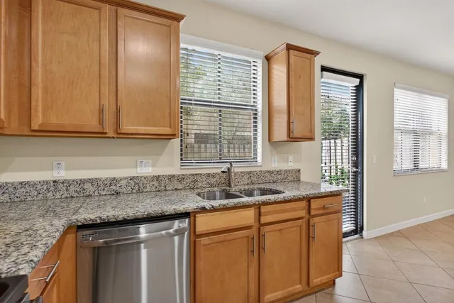 a kitchen with stainless steel appliances granite countertop cabinets sink and window