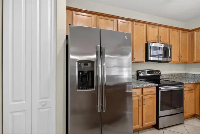 a kitchen with stainless steel appliances granite countertop a refrigerator and a stove top oven