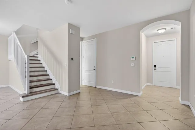 a view of a livingroom with white cabinets and entryway