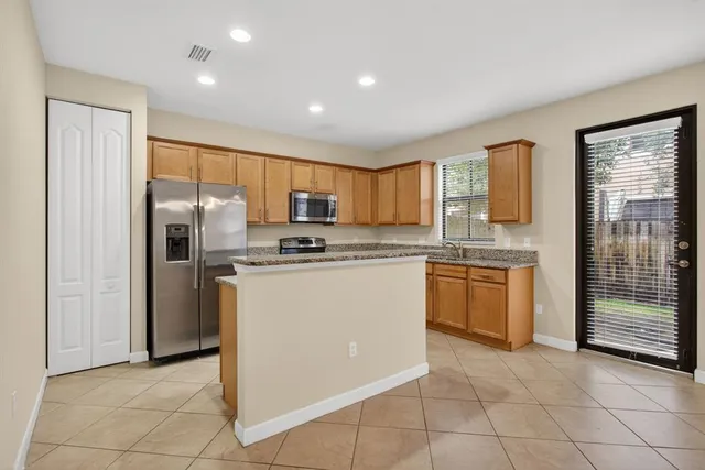 a kitchen with stainless steel appliances granite countertop a refrigerator sink and cabinets