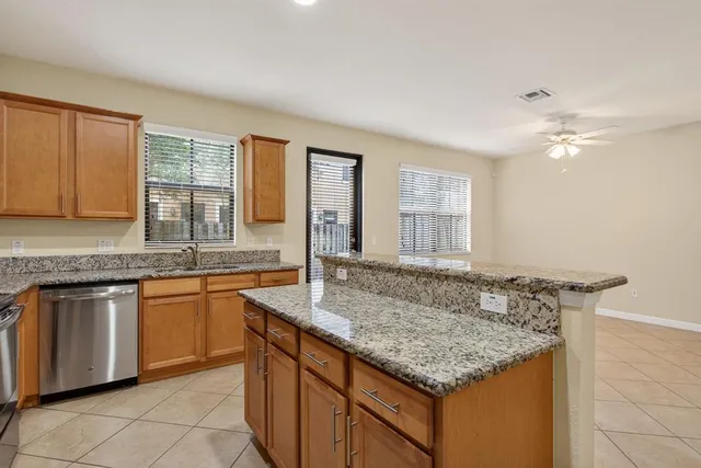 a kitchen with granite countertop sink stove and cabinets