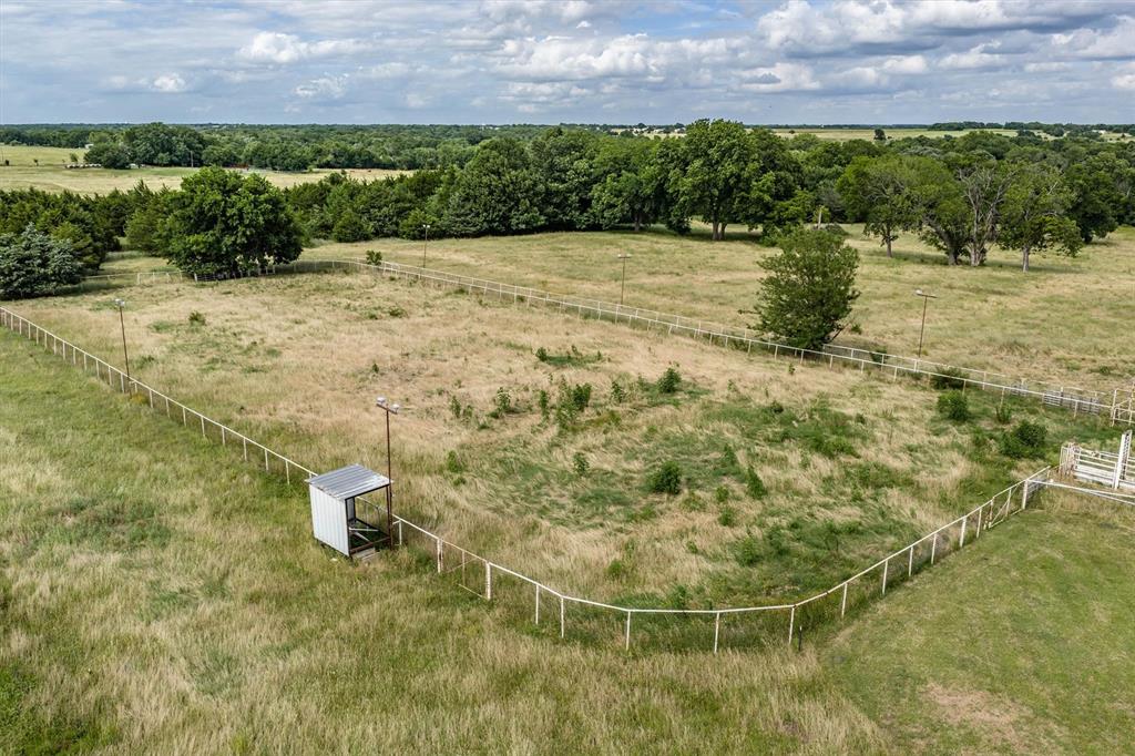 13132 Highway 78 Blue Ridge, TX 75424 - Photo 28 of 35 Fenced pastureland with a covered shelter, featuring extensive natural landscaping and distant tree lines