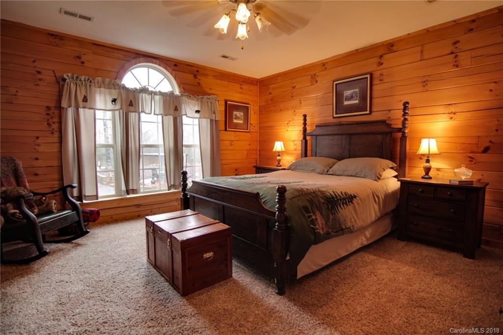 321 River Ridge Parkway, Unit 29 Rutherfordton, NC 28139 - Photo 23 of 33 a bedroom with a bed and a chandelier
