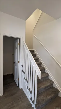 a view of staircase with wooden floor and white walls