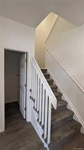 a view of staircase with wooden floor and white walls