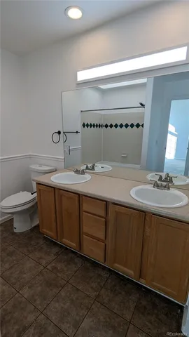 a bathroom with a granite countertop sink a toilet and a mirror