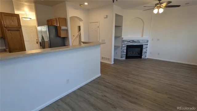 a view of kitchen with granite countertop cabinets and refrigerator
