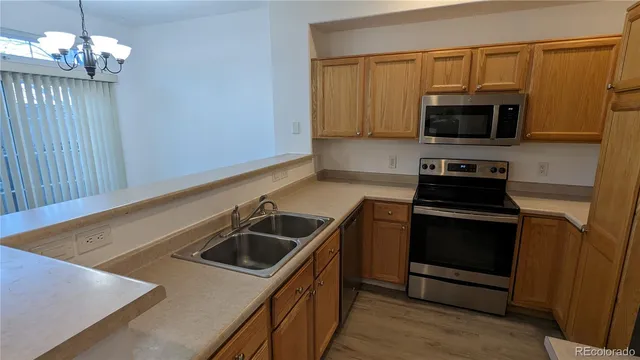 a kitchen with granite countertop a sink a stove and microwave
