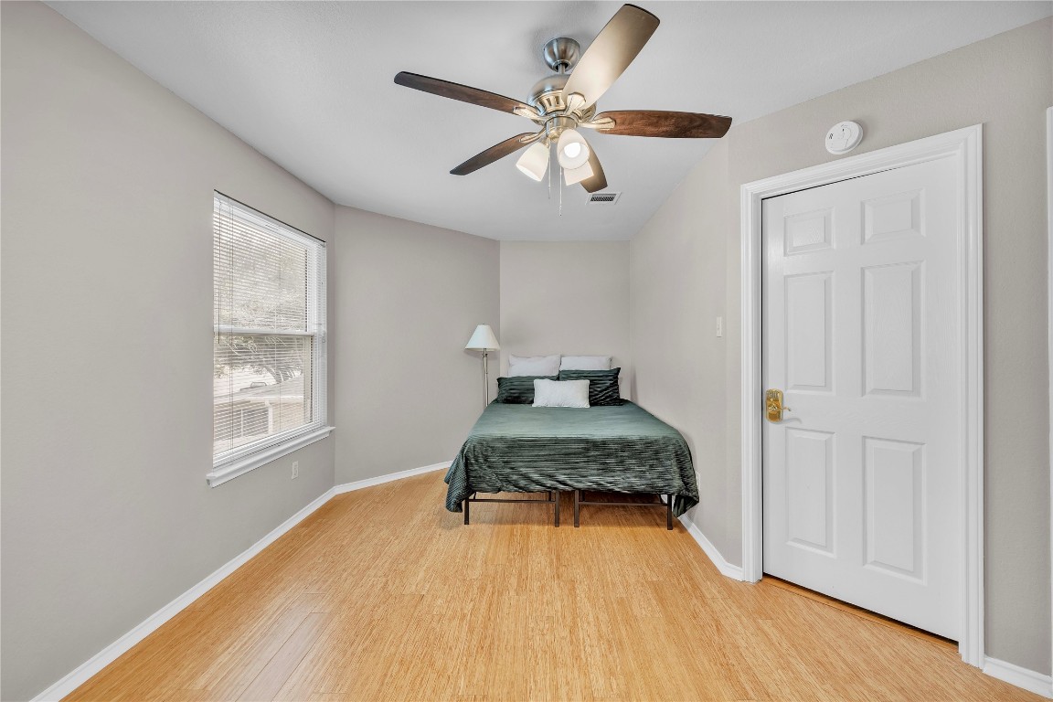 11713 Rydalwater Lane Austin, TX 78754 - Photo 18 of 29 a bedroom with a bed and wooden floor