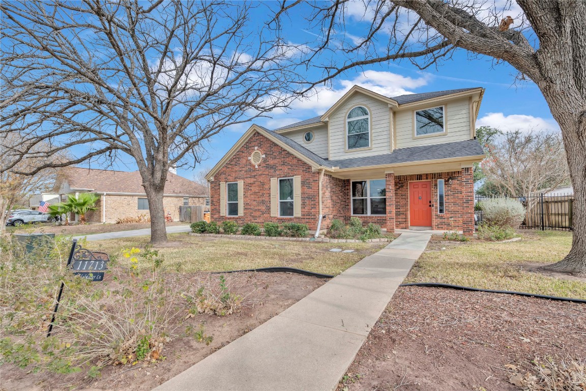 11713 Rydalwater Lane Austin, TX 78754 - Photo 2 of 29 a view of a brick house next to a yard with big trees