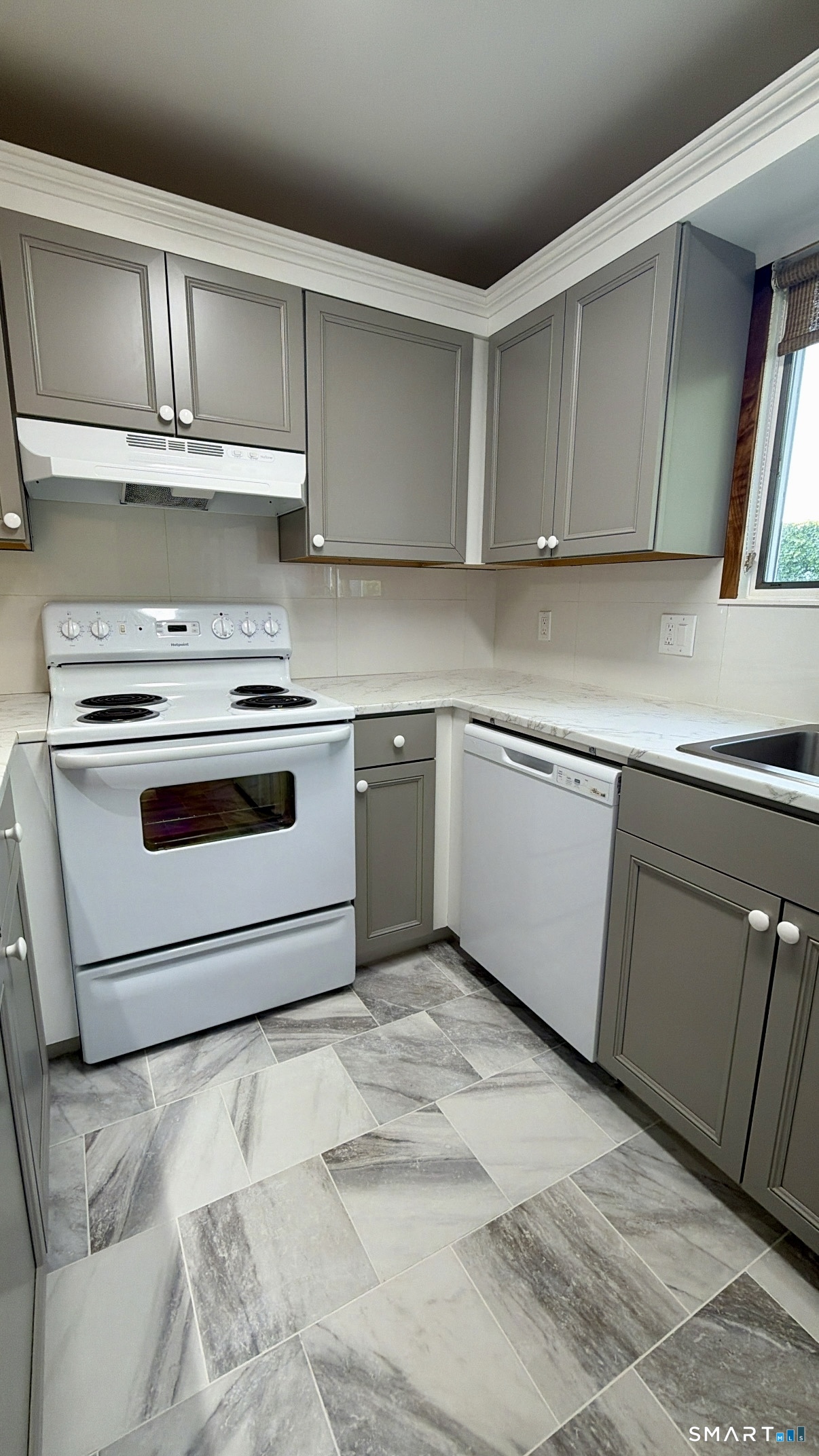 25 Cottage Street, Unit 202 Norwalk, CT 06855 - Photo 5 of 24 a kitchen with granite countertop a sink and a stove top oven