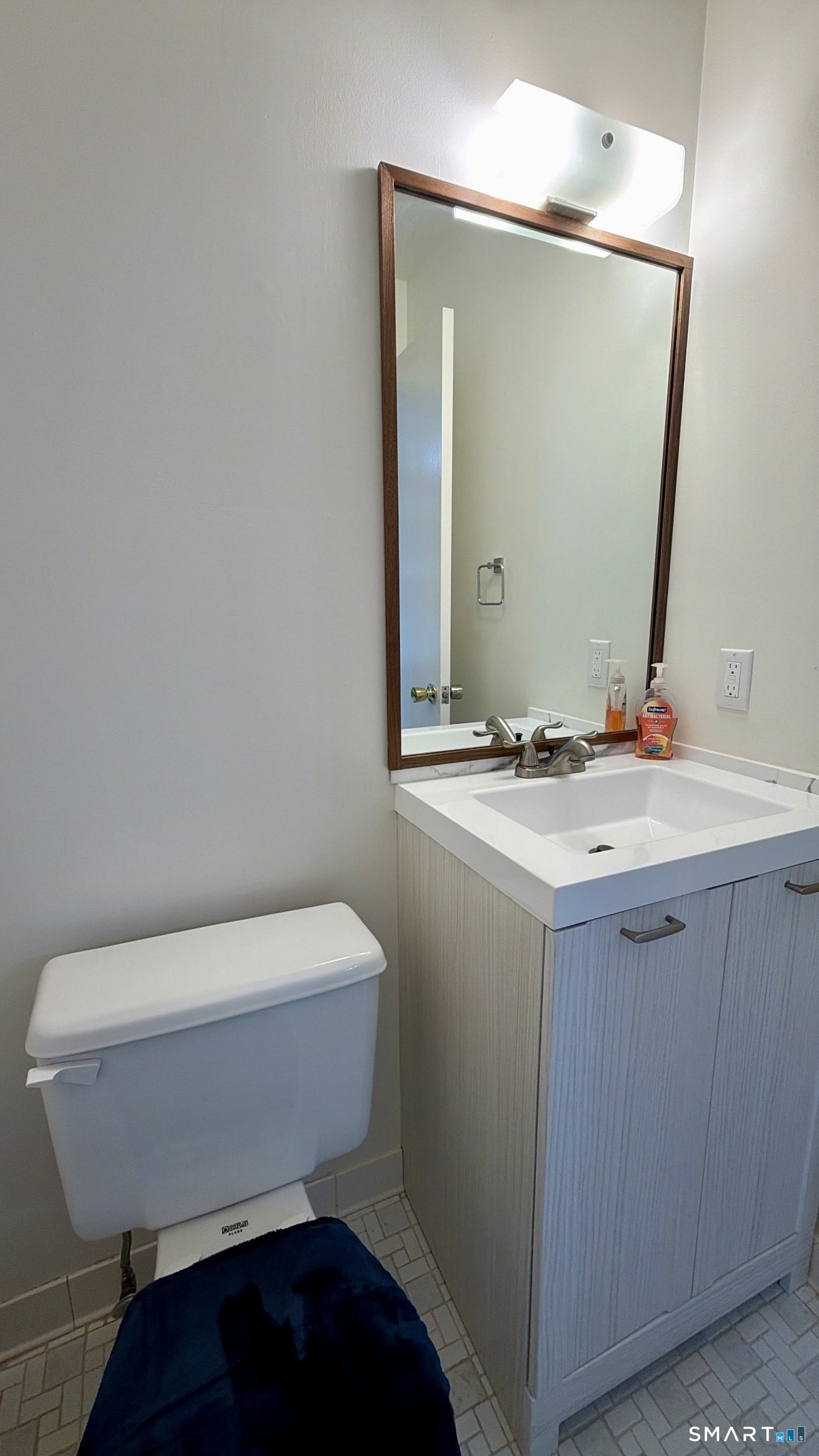 25 Cottage Street, Unit 202 Norwalk, CT 06855 - Photo 7 of 24 a bathroom with a toilet a sink and mirror