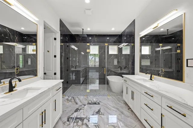 a large bathroom with a double vanity sink a large mirror and shower