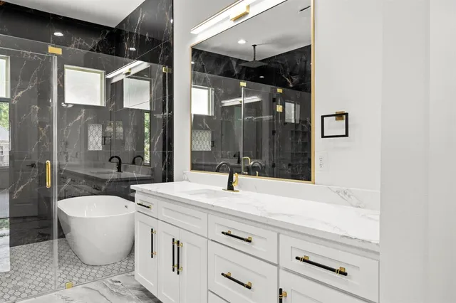 a bathroom with a bathtub shower sink and mirror