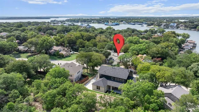 an aerial view of a house with a yard and lake view