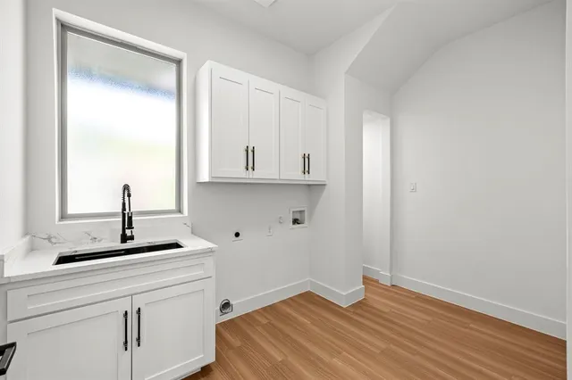 a kitchen with a sink cabinets and wooden floor