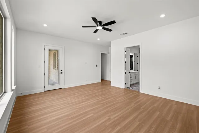 a view of empty room with wooden floor and ceiling fan