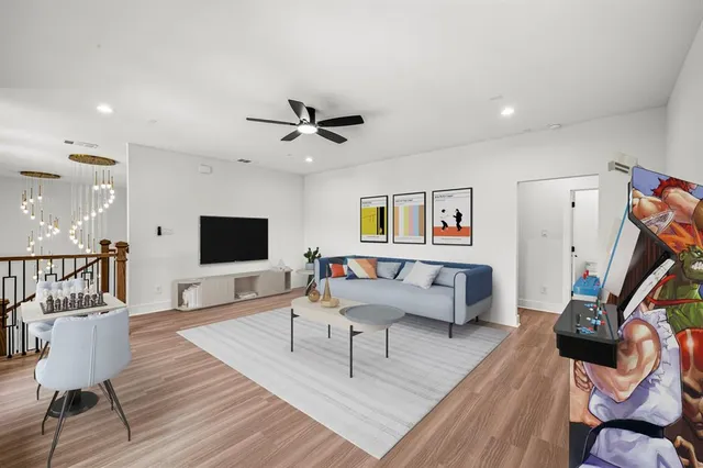 a living room with furniture a flat screen tv and a wooden floor