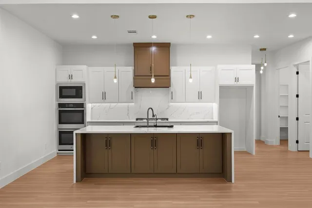 a kitchen with kitchen island a sink stainless steel appliances and cabinets