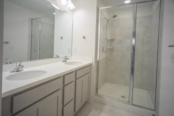 a bathroom with a shower sink and mirror