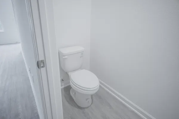 a white toilet sitting next to a shower