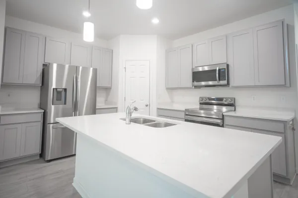 a kitchen with stainless steel appliances a microwave sink and refrigerator